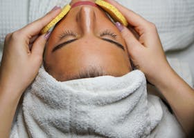 Relaxing spa treatment with facial and sponge massage in a serene environment.